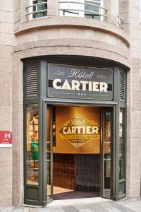 un deposito di portaerei nuvoloso con le porte aperte su un edificio di Hôtel Cartier a Saint Malo