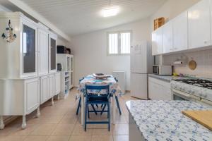 a kitchen with white cabinets and a table with a table cloth at Loft Le Palme in Portopalo