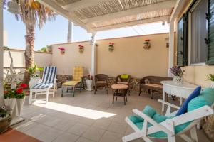 a patio with chairs and a table and chairs at Loft Le Palme in Portopalo