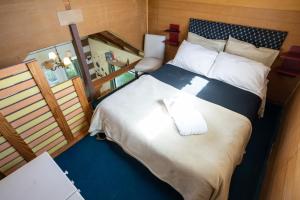 1 dormitorio con 1 cama y 2 toallas plegables. en Placeres, en San Carlos de Bariloche