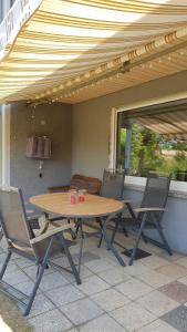 Une table et des chaises en bois sont disponibles sur la terrasse. dans l'établissement glüxnest, à Dornstadt