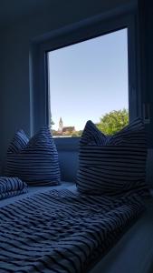 two pillows sitting on a bed in front of a window at glüxnest in Dornstadt