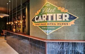 a sign on the wall of a bar with a pitcher carrier at Hôtel Cartier in Saint Malo