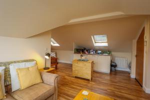 a living room with a couch and a kitchen at Birds Nest, Romantic getaway with stunning views in Matlock