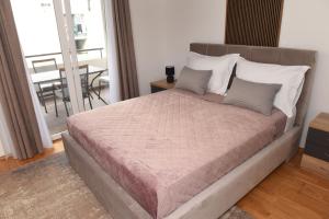 a bedroom with a large bed with a balcony at Navigo in Ploče