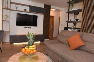 una sala de estar con sofá y un bol de fruta en una mesa en Navigo, en Ploče