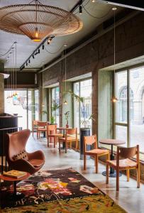 a room with chairs and tables and windows at Hôtel Cartier in Saint Malo
