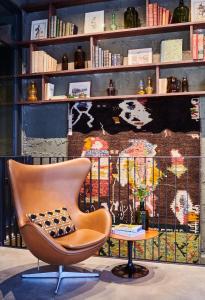 une chaise et une table devant un mur dans l'établissement Hôtel Cartier, à Saint-Malo