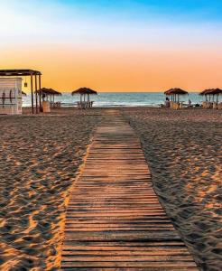 a wooden pathway on a beach with umbrellas at Valencia Doble A Deluxe in Valencia