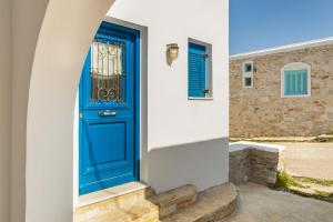 a blue door on the side of a house at Piperi-2 Bedroom home in Naousa