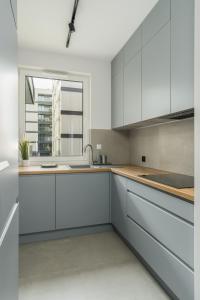 a kitchen with white cabinets and a window at Osiedle Goplana Apartment FREE GARAGE by Renters in Poznań