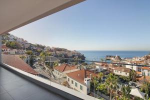 a view of the ocean from the balcony of a house at Sunset Bliss Apartment in Câmara de Lobos