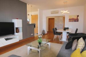 ein Wohnzimmer mit einem Sofa, einem TV und einem Tisch in der Unterkunft Golf Mar Village By Vilamoura Sun Vista Golfe in Vilamoura