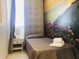 ein Schlafzimmer mit einem Bett mit einem Blumengemälde an der Wand in der Unterkunft Golf Mar Village By Vilamoura Sun Vista Golfe in Vilamoura
