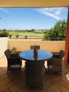 einen Tisch mit Stühlen und eine Vase auf einer Terrasse in der Unterkunft Golf Mar Village By Vilamoura Sun Vista Golfe in Vilamoura
