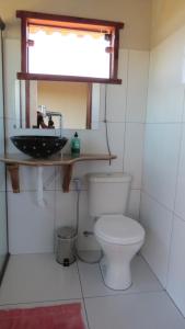 łazienka z toaletą i umywalką w obiekcie ninho da arara w mieście São Jorge