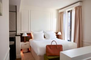 um quarto de hotel com uma cama grande com um saco vermelho em Maison Delano Paris em Paris