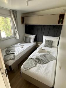 een kleine kamer met 2 bedden en een raam bij La Mer Mobil Home in Biograd na Moru