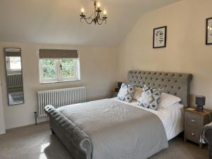 a bedroom with a large bed and a chandelier at Blacksmiths Cottages in Filey