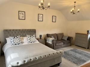 um quarto com uma cama, um sofá e uma cadeira em Blacksmiths Cottages em Filey
