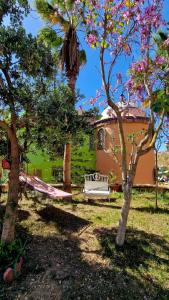 a hammock in a yard with trees and a house at Casa Paraiso in Benajarafe