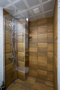 um chuveiro com paredes de madeira e uma porta de vidro em 8 Rooms House em Balçova