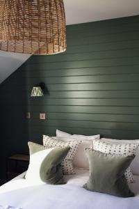 - une chambre avec des murs verts et un lit avec des oreillers blancs dans l'établissement Gara Rock, à Salcombe