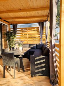 a patio with a couch and a table and chairs at La Mer Mobil Home in Biograd na Moru