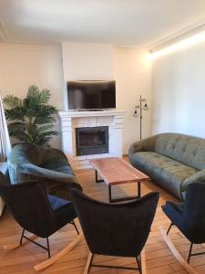 a living room with a couch and chairs and a fireplace at Maison Nausikaa in Ostend