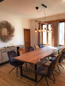 Un comedor con una gran mesa y sillas de madera. en Maison Nausikaa, en Ostende