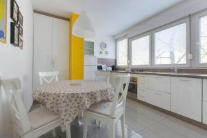 uma cozinha com mesa e cadeiras e uma cozinha com armários brancos em Central point em Zagreb