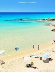 a group of people on a beach with umbrellas at Elisart Guest House in Alghero