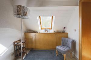 une chambre avec une chaise, une lampe et une fenêtre dans l'établissement Gîte Le Bijou et Spa, à Weiterswiller