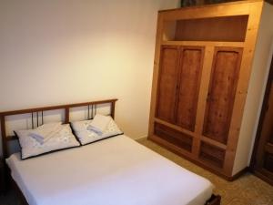 リーパリにあるCasa Tina&Rosyの白いベッドと木製キャビネット付きのベッドルーム1室が備わります。