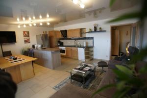 ein Wohnzimmer und eine Küche mit einem Sofa und einem Tisch in der Unterkunft Ferienwohnungen Gästehaus Schreiner in Arrach