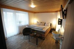 1 dormitorio con 1 cama y 1 silla en Ferienwohnungen Gästehaus Schreiner, en Arrach