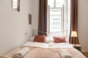 a bed with two pillows and a window in a room at Comfortable 2BR Apt Central and Well Connected in Vienna