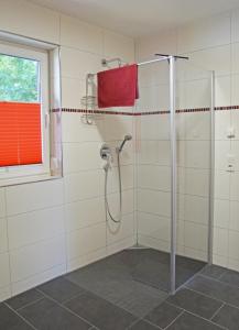 uma casa de banho com um chuveiro e uma toalha vermelha em Ferienwohnungen am Roten Nil em Lübben