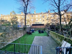 ロンドンにあるOxford Gardens Apartmentsの椅子付きの庭のある建物の景色を望めます。