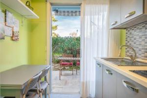 a kitchen with a sink and a door to a patio at Appartement familial 6P, avec piscine et tennis, proche mer in Roquebrune-Cap-Martin