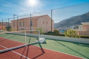a tennis court with a net on a tennis court at Appartement familial 6P, avec piscine et tennis, proche mer in Roquebrune-Cap-Martin