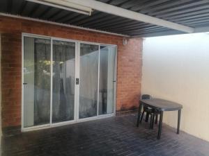 a patio with a table and a glass door at Runwayghouse in Johannesburg