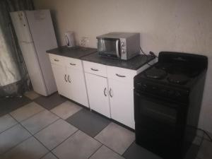 a kitchen with a microwave and a stove at Runwayghouse in Johannesburg