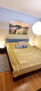 una camera da letto con un letto e un dipinto sul muro di Lakeside Apartments - Adults Only a Faak am See