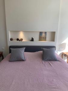 a bedroom with a large bed with two pillows at La Zoulette in Louveigné