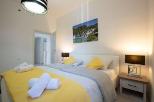 een slaapkamer met een groot geel bed met witte kussens bij MS 3BR Apartment near Kolovare beach in Zadar