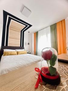 a bedroom with a bed and a vase with a flower in it at Confort Apartament in Ploieşti