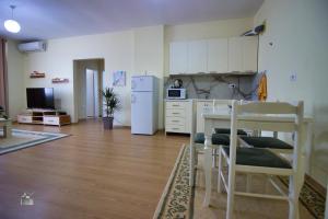 a kitchen with a white refrigerator and a table and chairs at DAI Apartments in Gjirokastër