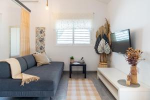 a living room with a blue couch and a tv at Apartamento Jibazahora Escorpio in Zahora