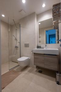 a bathroom with a toilet and a sink and a shower at Terra Luxe Residences in Sajmište